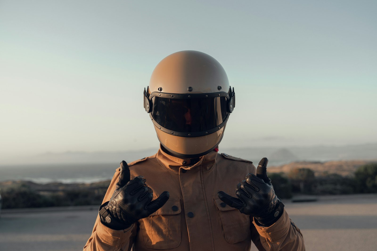 Motorista con chaqueta negra y casco blanco